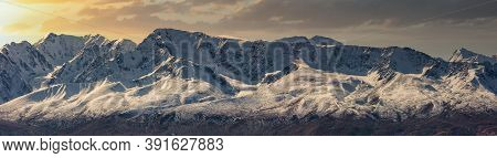 Scenic Panoramic Aerial View Of Snowy Mountain Peaks And Slopes Of North Chuyskiy Ridge At Sunset. B