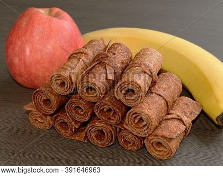 Apple-banana Pastille Is On The Table Surrounded By An Apple And A Banana