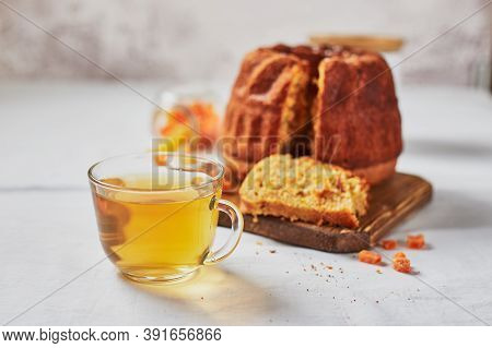 Homemade Autumn Carrot Or Pumpkin Bundt Cake With Candied Fruits, Cup Of Tea And Golden Decorative P