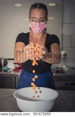 Young woman with mask makes a non-industrial homemade cake