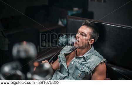 Sexy Guy Smokes A Fragrant Oriental Hookah At Arabic Restaurant.