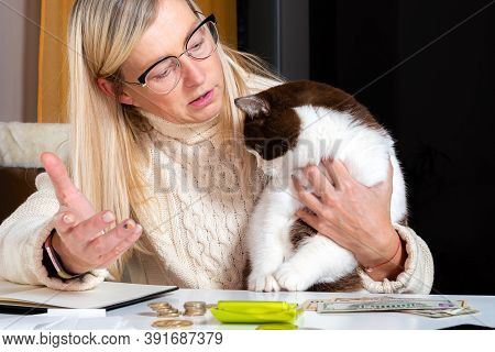 Middle-aged Female Accountant Working From Home And At Rest Taking A Cat On Her Lap And Talking To H