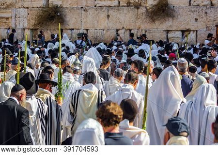 JERUSALEM, ISRAEL - SEPTEMBER 26, 2018: The Jews of ritual clothes - tallit hold four ritual plants. Morning autumn Sukkot. Thousands of Jews, wrapped in tallits, pray at the Wailing Wall. 