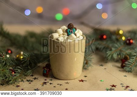 A Gingerman In A Mug With Hot Cocoa And Marshmallow. Christmas Holiday Decorations And Blurred Xmas 