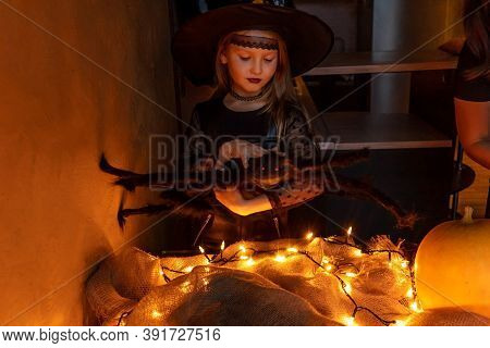 Child Girl Preparing To Celebrate Halloween In Witch Costume. Big Spider In Hand As Decor. Pumpkin I