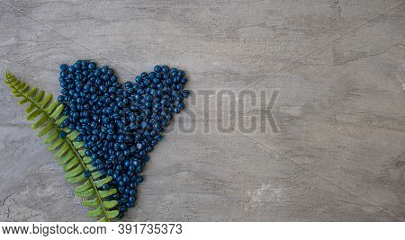Wax Film For Depilation With Azulene Granules In The Shape Of A Heart On A Gray Background.