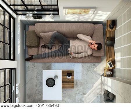 Man lying on couch at home, working from home with tablet, home office. above the head view.