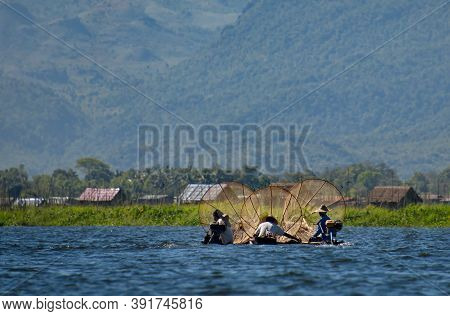 Nanthe. Myanmar. November 27, 2016. Clownfishermen On Inle Lake Pose In Front Of Tourist Photographe