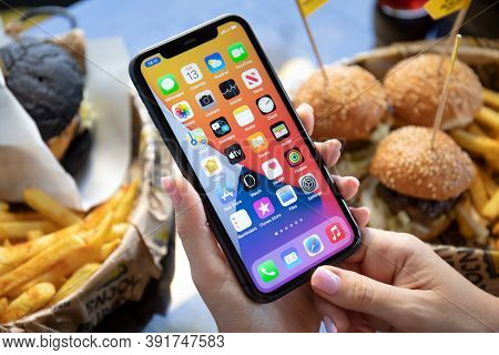 Alanya, Turkey - October 13, 2020: Woman Hand Holding Iphone 11 With Home Screen Ios 14 On The Scree