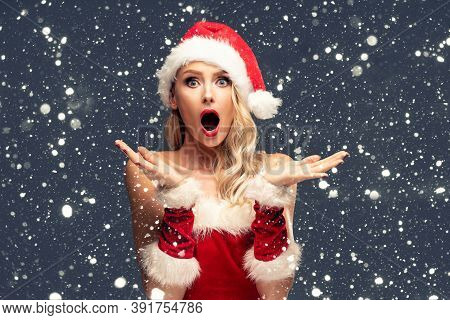 Beautiful Shocked Santa Girl, Caucasian Woman, In Red Hat Posing Over Snowfalkes.