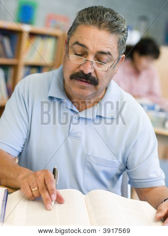 図書室の本とメモ帳 （選択的フォーカス） に座っている男