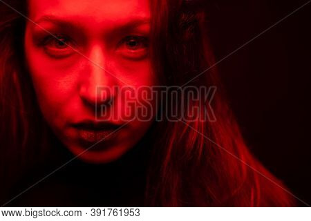 Low Key Portrait Of Pretty Full-face Tired Girl With Swollen Eyelids Looking At Camera Dilated Pupil