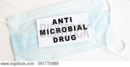 White Card With The Inscription Anti Microbial Grug A Medical Protective Mask. Medical Concept.