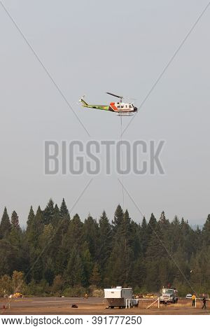 Prospect,  Oregon / Usa - September 13, 2014:  A Fire Fighting Helicopter Takes Off In A Smoke Fille