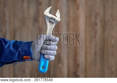 The Master Holds In His Hand An Adjustable Locksmith Key With A Blue Handle. Locksmith Repair Work