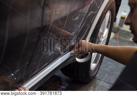 Master Pastes Over Plastic Part Of Threshold Of Black Car Body With Protective White Tape To Prevent