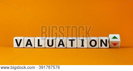 Valuation Word On Wooden Cubes, Up And Down Signs On Orange Background. Business Concept, Copy Space