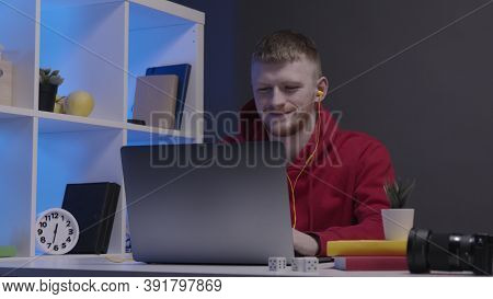 A Video Maker Or Designer In A Red Sweatshirt Works At A Computer From Home. Creative Workspace With