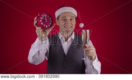 Cheerful Excited 40s Man In Santa Hat Holds Alarm Clock Seconds Before Midnight Drinking Champagne O