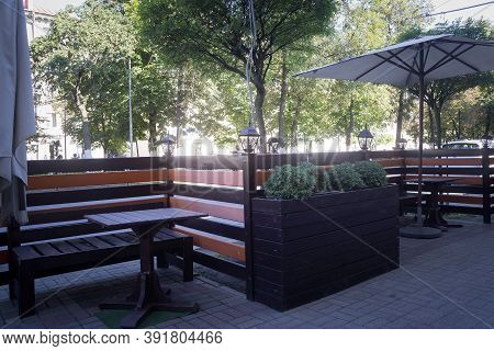 Tables, Chairs And Beautiful Bright Flowers In Street Cafes. Fall.