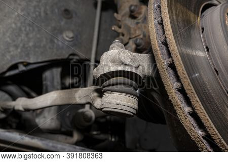 The End Of The Tie Rod Ends With A Rubber Connector, The Brake Disc Is Visible.