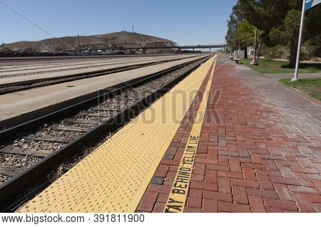 Long Parallel Merging Train Tracks And And Platform Converging Into A Blurred Background.