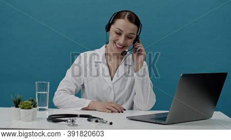 Beautiful Positive Doctor In White Coat And Headphones Talking On Phone, Specialist Of Call Center R