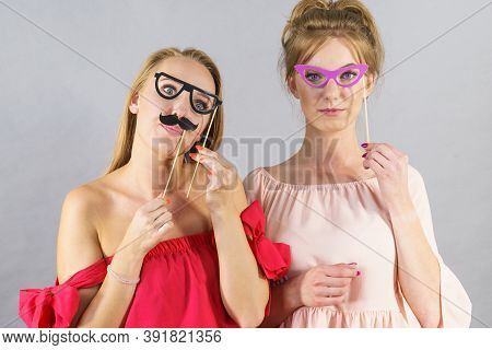 Happy Two Women Holding Paper Decoration Photo Booth Mask Glasses And Moustache On Stick, Having Fun