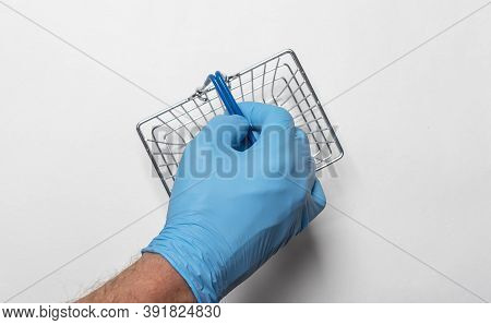 Shopping Metal Empty Basket In Male Hand In Blue Protecive Glove. Shopping During Coronavirus Lockdo