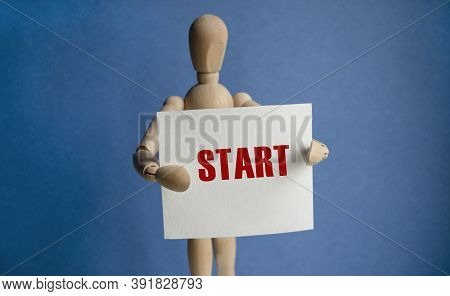 A Wooden Man On A Blue Background Holds A White Piece Of Paper With The Words Start The Content Of T