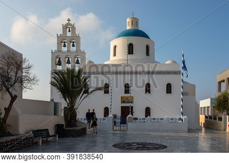 Oia, Santorini Island, Greece- 18 September 2020: The Orthodox Church Of Panagia Platsani With A Gre