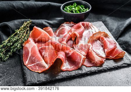 Italian Rolled Bacon Pancetta Piacentina. Pork Meat. Black Background. Top View