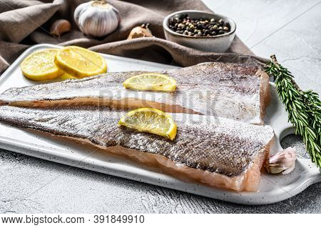 Fresh Raw Hake Fish Fillet With Pepper And Lemon. White Background. Top View