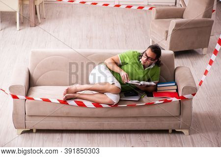 Young male student studying at home in self-isolation concept