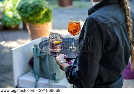 Two Glasses Of Liquor Or Cocktail Longdrinks On A Plate Served In A German Biergarten Of A Vineyard 