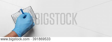 Shopping Metal Empty Basket In Male Hand In Blue Protecive Glove. Shopping During Coronavirus Lockdo