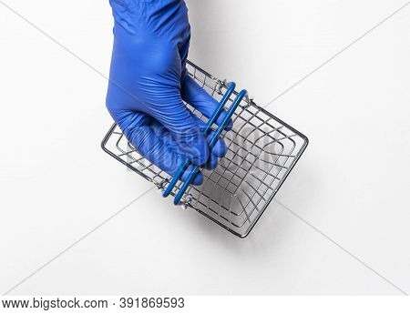 Shopping Metal Empty Basket In Male Hand In Blue Protecive Glove. Shopping During Coronavirus Lockdo