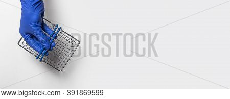 Shopping Metal Empty Basket In Male Hand In Blue Protecive Glove. Shopping During Coronavirus Lockdo