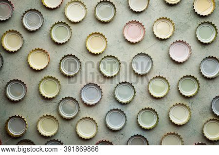 Collection of bottle caps on a stone table.