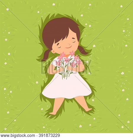 Top View Of Adorable Brunette Girl Lying Down On Green Lawn, Cute Kid Lying On Grass Dreamily Lookin