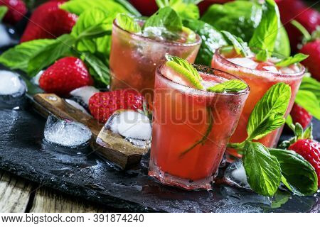 Alcoholic Cocktail Strawberry Mojito With White Rum, Syrup, Soda, Lime, Mint And Ice, Black Backgrou