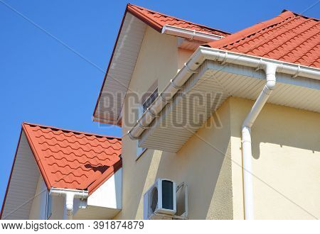 A Stucco House With A Red Metal Roof, Attic And Air Conditioner Outdoor Unit With A Close-up On A Wh