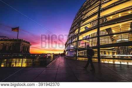 Berlin, Germany - 19 September 2020: Lonely tourist walking along evening Reichstag
