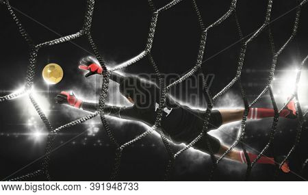 Soccer goalkeeper catches the ball on dark background â Matte image 