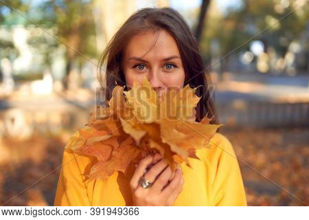 Beautiful Caucasian Young Woman Walking And Having Fun Outdoors In Autumn Time. Bright Yeallow Color