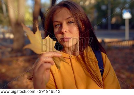 Beautiful Caucasian Young Woman Walking And Having Fun Outdoors In Autumn Time. Bright Yeallow Color