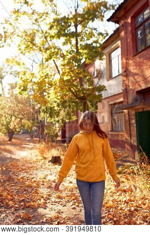 Beautiful Caucasian Young Woman Walking And Having Fun Outdoors In Autumn Time. Bright Yeallow Color