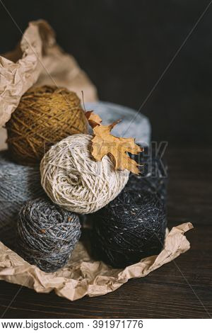 Cozy Balls Of Yarn For Hand Knitting With Dry Oak Leaf On A Dark Background. Autumn Background For H