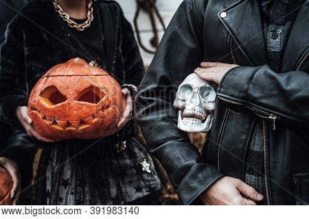 Pumpkins Jack-o-lantern And Skull In Hands. Scary Family Father,daughter Celebrating Halloween. Styl