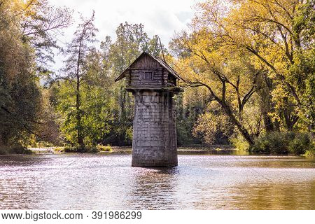 Wooden Cottage On Abandoned Bridge Pillar In Autumn Sunny Day